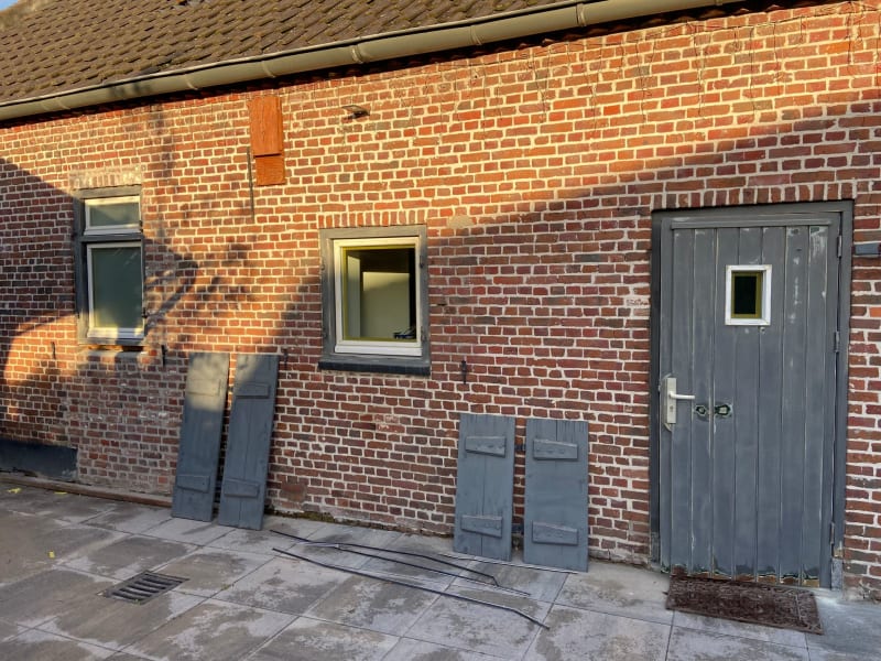 Picture of a brick wall with the door and windows unpainted